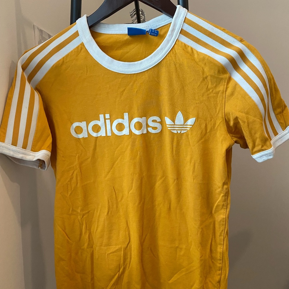 Yellow Adidas T-shirt w/ stripe detail & felt logo on chest. Rib neckline/cuffs.